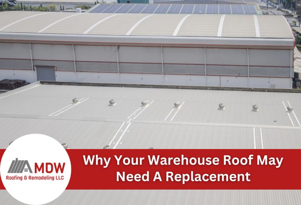 Industrial warehouse with flat roof and solar panels showing potential replacement needs