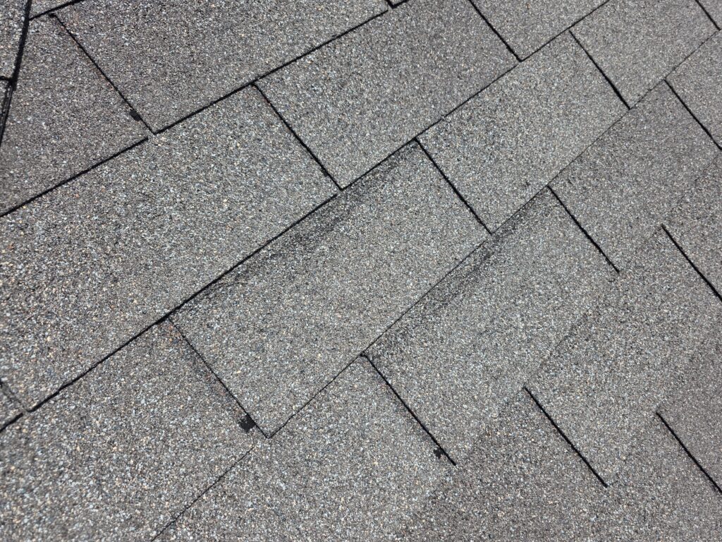 Close-up view of gray asphalt roof shingles in a diagonal layout.
